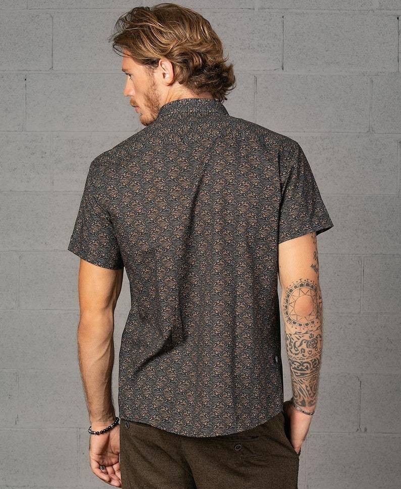 May include: A short-sleeved button-down shirt with a brown and black abstract pattern. The shirt has a collared neckline and a relaxed fit.