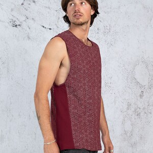 Puede incluir: Una camiseta sin mangas de color burdeos con un dise&ntilde;o estampado en blanco. La camiseta tiene un escote redondo y un corte holgado.