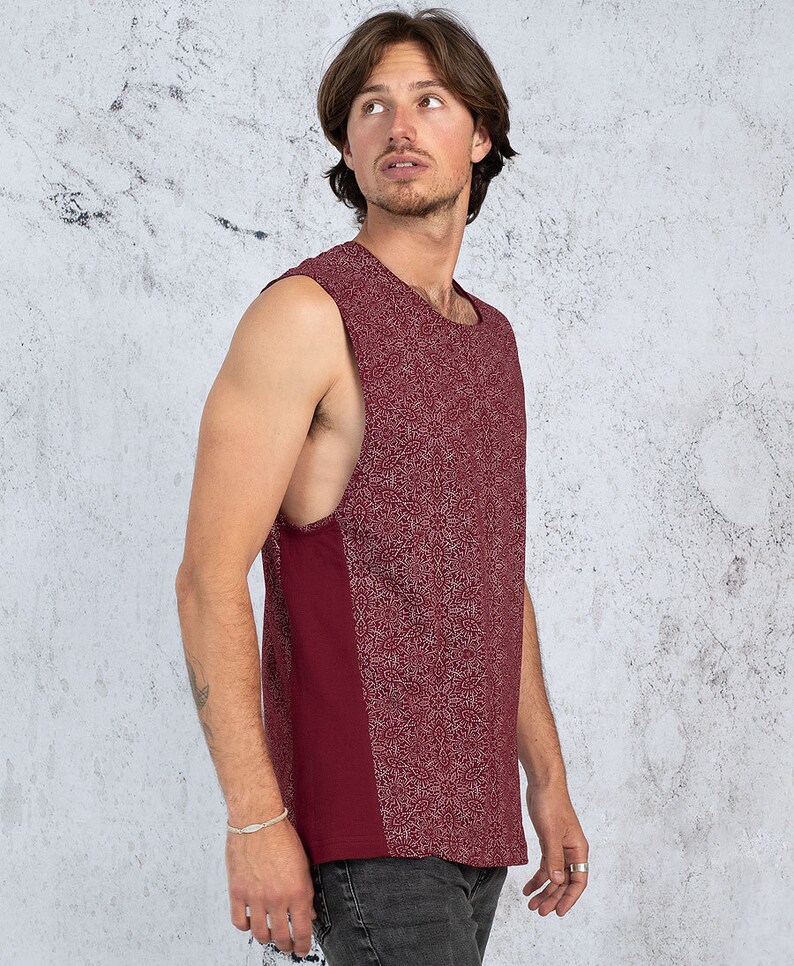 Puede incluir: Una camiseta sin mangas de color burdeos con un dise&ntilde;o estampado en blanco. La camiseta tiene un escote redondo y un corte holgado.