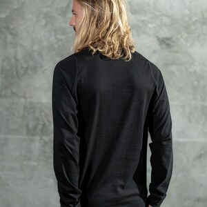 May include: A black long-sleeved shirt with a crew neck.