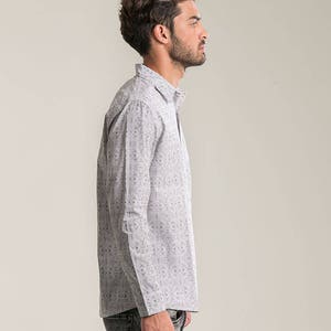 May include: A white long-sleeved button-down shirt with a black and white geometric pattern.