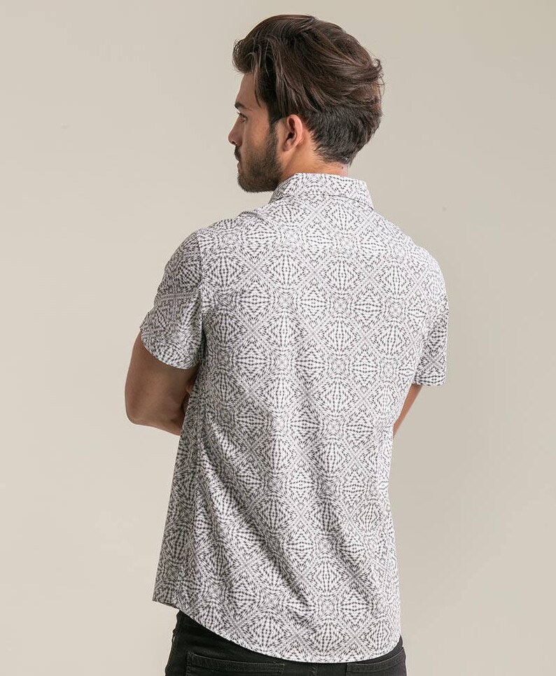 May include: A white short-sleeved button-down shirt with a black geometric pattern.