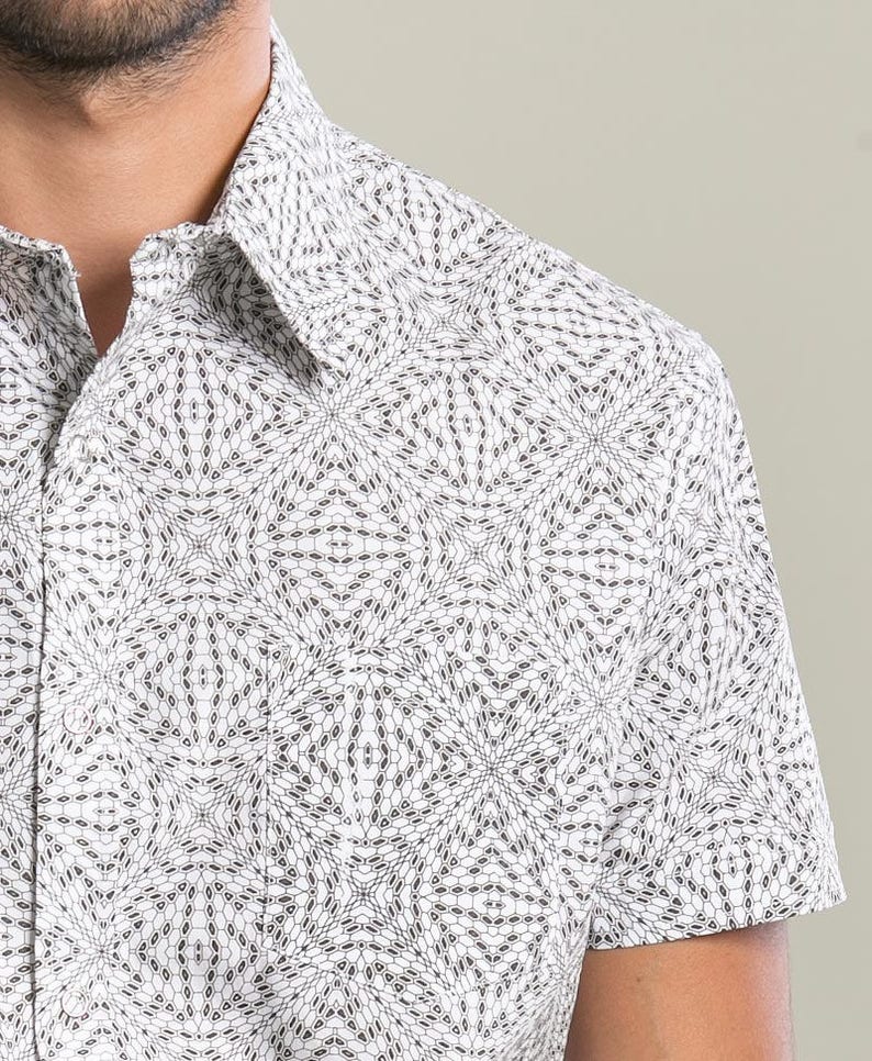 May include: A white short-sleeved button-down shirt with a geometric pattern in black.