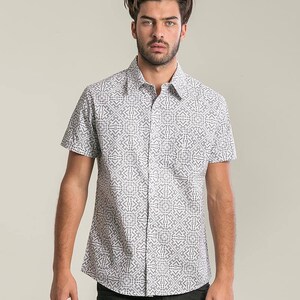 May include: A white short-sleeved button-down shirt with a black geometric pattern.