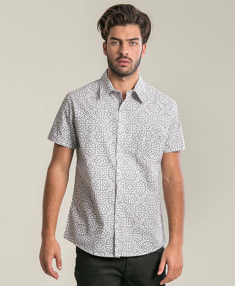May include: A white short-sleeved button-down shirt with a black geometric pattern.