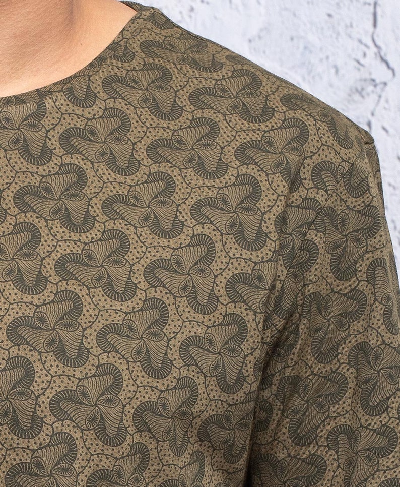 May include: A green long-sleeved shirt with a brown and black abstract pattern.