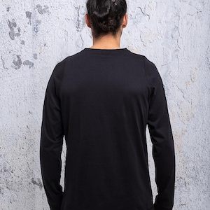 May include: A black long-sleeved t-shirt with a crew neck.