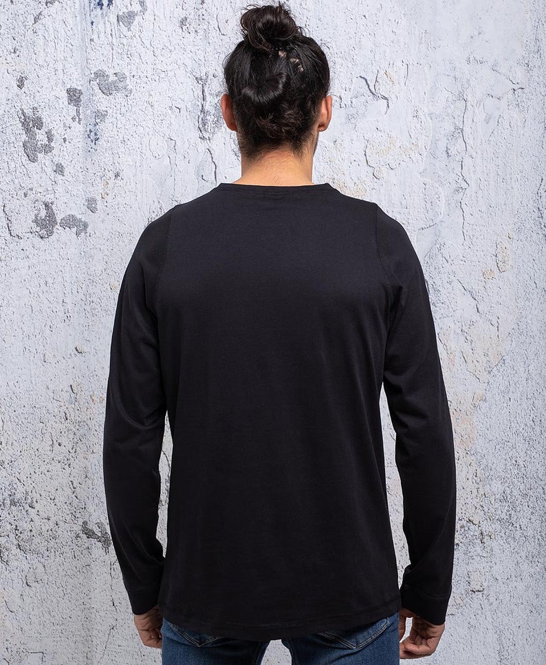 May include: A black long-sleeved t-shirt with a crew neck.