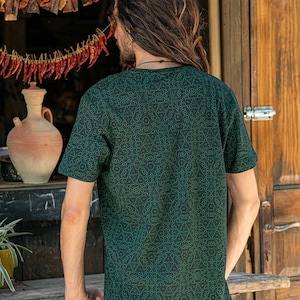 May include: A dark green t-shirt with a geometric pattern. The shirt has a crew neck and short sleeves.