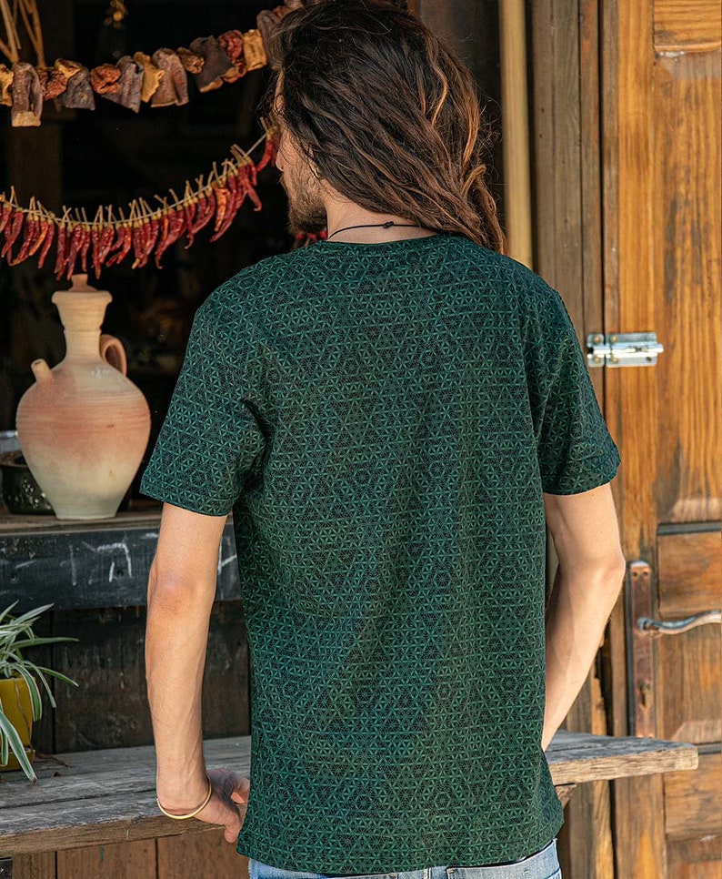 May include: A dark green t-shirt with a geometric pattern. The shirt has a crew neck and short sleeves.