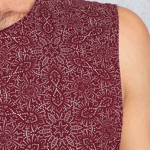 Puede incluir: Una camiseta sin mangas con fondo granate y un patr&oacute;n geom&eacute;trico blanco.