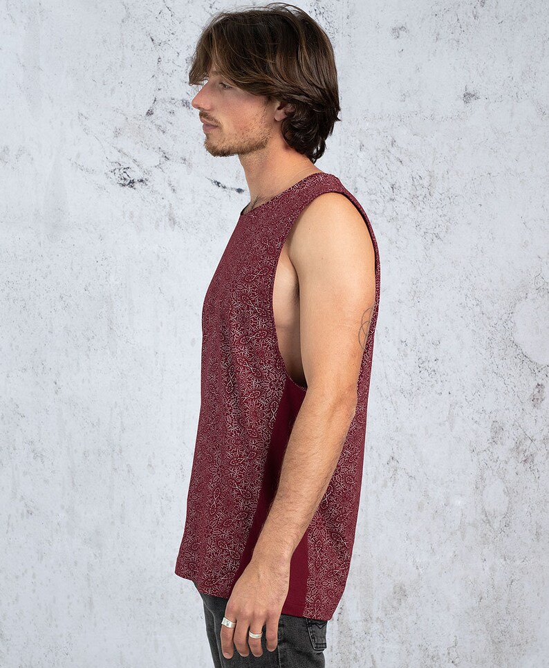 Puede incluir: Una camiseta sin mangas de color burdeos con un dise&ntilde;o estampado en blanco. La camiseta tiene un escote redondo y un corte holgado.