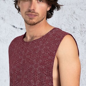 Puede incluir: Una camiseta sin mangas con fondo burdeos y un patr&oacute;n blanco de peque&ntilde;as formas abstractas.