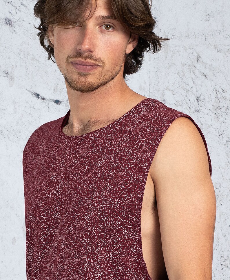 Puede incluir: Una camiseta sin mangas con fondo burdeos y un patr&oacute;n blanco de peque&ntilde;as formas abstractas.