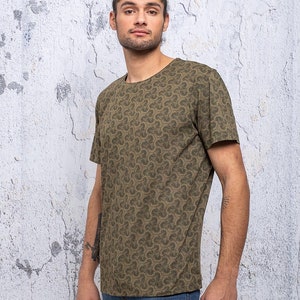 May include: A green short-sleeved t-shirt with a repeating pattern of small clover shapes.