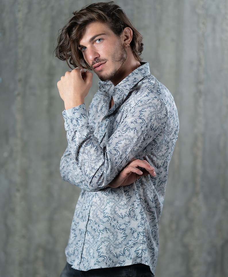 May include: A white long-sleeved shirt with a blue and white patterned design. The shirt has a button-down collar and a relaxed fit.