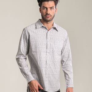May include: A white long-sleeved button-down shirt with a black geometric pattern.