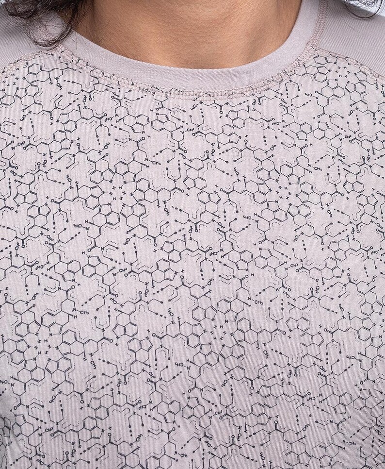May include: A light gray t-shirt with a repeating pattern of black chemical structures.