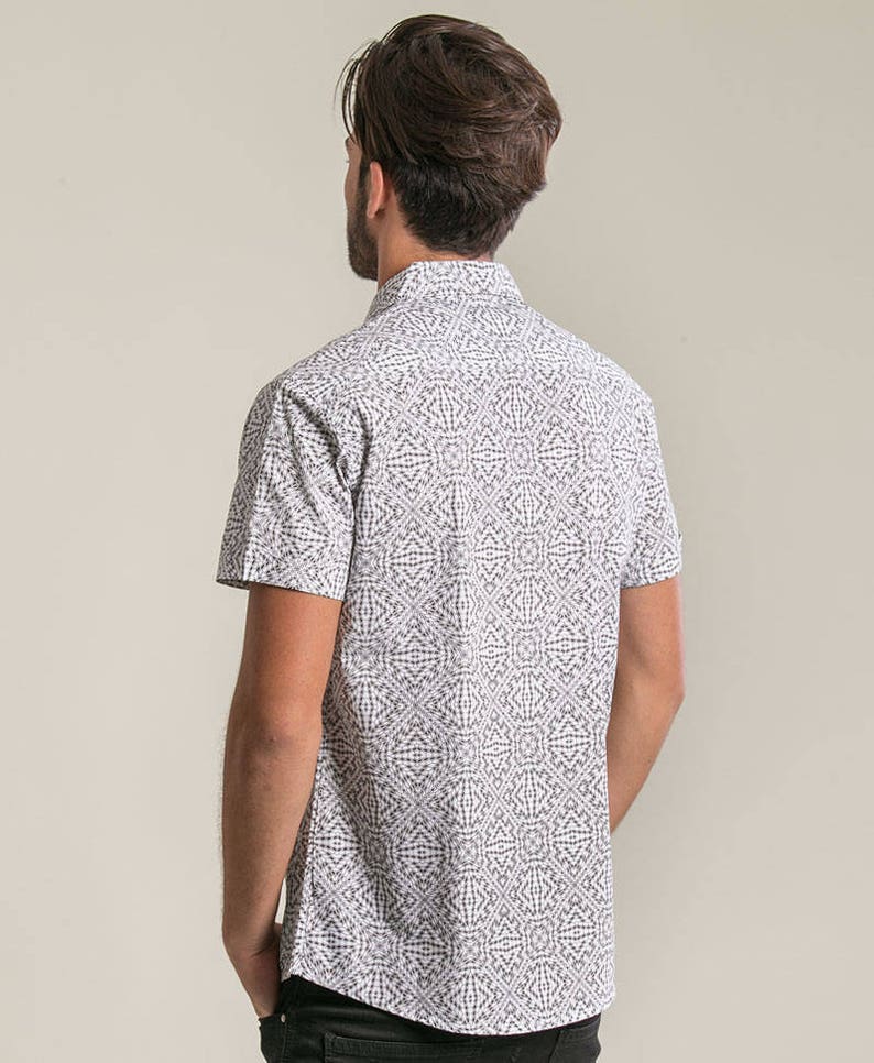 May include: A white short-sleeved button-down shirt with a black geometric pattern.