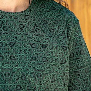 May include: A green short-sleeved shirt with a geometric pattern of small green circles and lines on a black background.