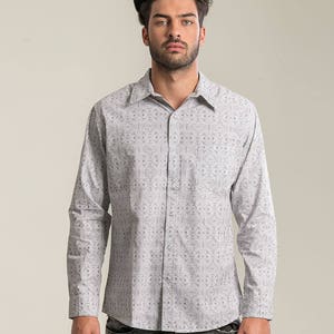 May include: A white long-sleeved button-down shirt with a black geometric pattern.