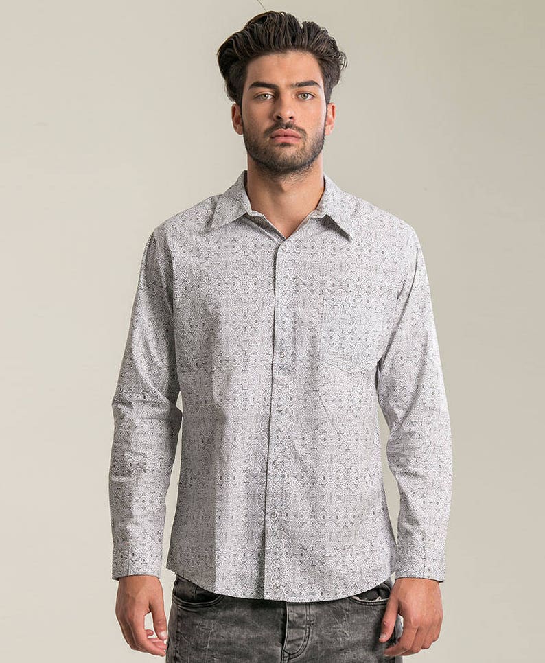 May include: A white long-sleeved button-down shirt with a black geometric pattern.