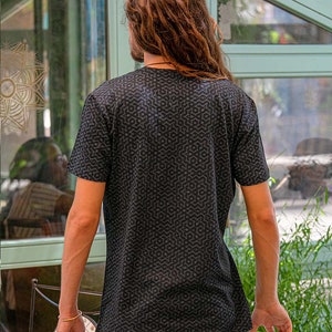 以下が含まれることがあります： 幾何学模様の黒いTシャツ。クルーネックと半袖です。