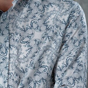 May include: A long-sleeved shirt with a white background and a blue and gray geometric pattern. The pattern is a repeating design of interlocking circles and lines.