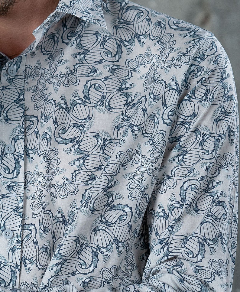 May include: A long-sleeved shirt with a white background and a blue and gray geometric pattern. The pattern is a repeating design of interlocking circles and lines.