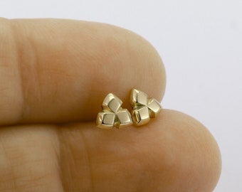 May include: A pair of gold-toned geometric stud earrings. Each earring is made of three small, square-shaped pieces.
