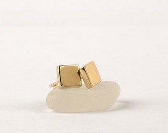 May include: A pair of gold square stud earrings. The earrings are small and simple, and they are perfect for everyday wear.