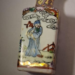 Liten vintage kinesisk exportvas av porslin med handmålad polykrom emaljdekoration av en traditionell figur i ett landskap