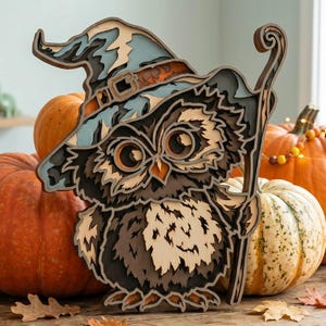 May include: A multi-layered wooden cutout of an owl wearing a pointed wizard hat and holding a staff. The owl features dark brown, light brown, and cream feathers with large orange eyes. The hat is light blue with a dark brown band and buckle.
