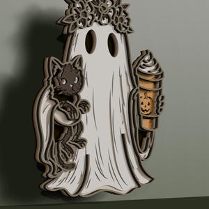 May include: A layered wooden wall decoration featuring a white ghost wearing a floral crown, holding a black cat on one side and a tan coffee cup with a jack-o'-lantern face design on the other. The piece has a dimensional, multi-layered appearance.