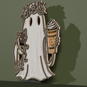 May include: A layered wooden wall decoration featuring a white ghost wearing a flower crown, holding a black cat in one arm and a tall coffee cup with a pumpkin jack-o'-lantern face design in the other hand, rendered in a multi-dimensional style.
