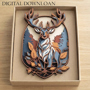 May include: A multi-layered wooden wall art piece featuring a deer with large antlers, surrounded by stylised trees and leaves in shades of blue, brown, and cream. The text DIGITAL DOWNLOAD is printed at the top of the rectangular box.
