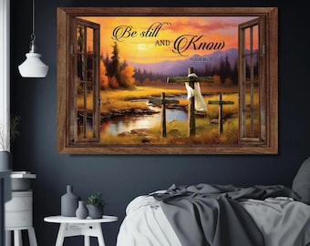 Könnte beinhalten: Ein gerahmter Wandkunstdruck, der eine ruhige Landschaft mit drei Holzkreuzen auf einem Feld zeigt. Das Kunstwerk zeigt einen Sonnenuntergang, einen Fluss und den Text "Be still and Know Psalm 46:10". Der Rahmen ist dunkelbraun.