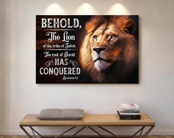 Puede incluir: Una impresión en lienzo rectangular que presenta una ilustración detallada de la cara de un león con una melena dorada. El texto "BEHOLD, The Lion of the tribe of Judah. The root of David. HAS CONQUERED Revelation 5:5" se muestra sobre un fondo oscuro similar a la madera.