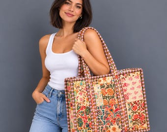 May include: A large rectangular tote bag featuring a patchwork design of various floral patterns in shades of red, orange, green, and cream. The bag has structured edges and two shoulder straps with a red and white striped trim.