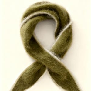 Puede incluir: Bufanda verde oliva con una textura suave y difusa. La bufanda está doblada en un bucle, con bordes blancos. La bufanda está hecha de un material suave y difuso. Es un accesorio de moda.