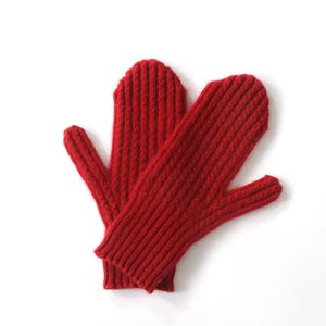 Puede incluir: Un par de mitones de punto rojo brillante. Los mitones tienen una textura acanalada y están diseñados para mantener las manos calientes. Hechos de un material suave y cálido, perfectos para el clima frío. Los mitones son de color rojo liso.