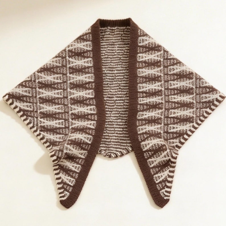 May include: A brown and cream-colored knitted shawl with a geometric pattern. The shawl has a dark brown border and a unique open front design. The pattern features a series of intersecting lines and shapes, creating a textured look. The shawl is made of a soft, warm material.