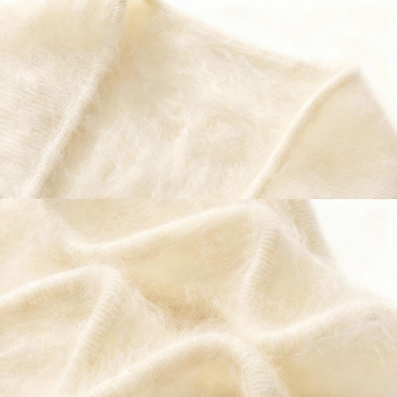 Peut inclure: Gros plan sur un pull en tricot cr&egrave;me et duveteux. Le tissu a un aspect doux et textur&eacute; avec des coutures visibles le long des coutures. Le pull semble &ecirc;tre fait d'un m&eacute;lange d&eacute;licat, peut-&ecirc;tre de laine ou de mohair.