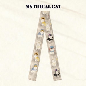 Könnte beinhalten: Hellgrauer Schal mit gestickten Katzenfiguren, die Hüte und Mäntel tragen. Der Text "MYTHICAL CAT" steht oben. Der Schal ist etwa 152 cm lang.