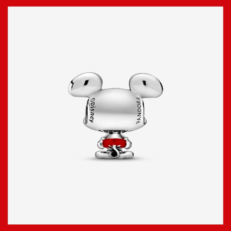 May include: A silver-colored charm in the shape of Mickey Mouse with the Disney and Pandora logos. The charm has a red accent and is set against a white background with a red border.