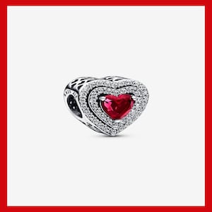 May include: A silver charm with a double heart design. The inner heart is a vibrant red, surrounded by a halo of clear, sparkling stones. The outer heart is also adorned with clear stones, creating a dazzling effect. The charm is marked with "925 ALE".