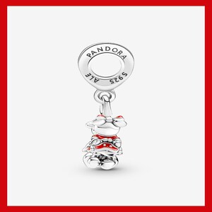 May include: A silver charm with a Minnie Mouse design. The charm features a round top with the word "PANDORA" and "S925 ALE" engraved. Minnie Mouse is wearing a red and white outfit with a red bow.