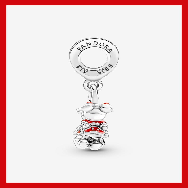 May include: A silver charm with a Minnie Mouse design. The charm features a round top with the word "PANDORA" and "S925 ALE" engraved. Minnie Mouse is wearing a red and white outfit with a red bow.