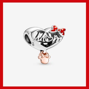 May include: A silver charm in the shape of a heart, with the word "Mom" in cursive. A red and white polka dot bow is at the top, and a rose gold Minnie Mouse head dangles below. This charm is a piece of jewellery.