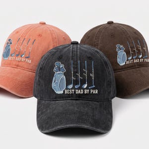 May include: Three baseball caps in shades of orange, brown, and black. Each cap features a golf bag and clubs graphic with the text "BEST DAD BY PAR". The black cap has names below the golf clubs.